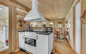 eine Küche mit weißen Geräten und ein Esszimmer in der Unterkunft Three-Bedroom Holiday Home In Martofte in Martofte + 18 Fotos