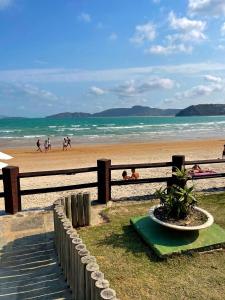 a beach with a fence and people on the beach at Geribá Dream House in Búzios