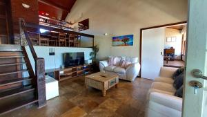a living room with a couch and a tv at Geribá Dream House in Búzios