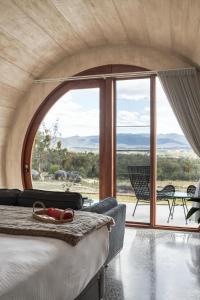 Zimmer mit einem Bett und einem großen Fenster in der Unterkunft Barrel View Luxury Cabins in Ballandean