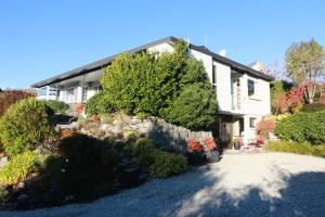 een huis met bomen en struiken ervoor bij STUDIO@746 in Queenstown