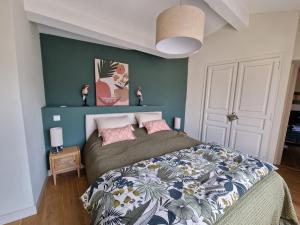 a bedroom with a bed with a green wall at MAISON BELLEVUE DE SAGRIES in Sagriès +32 photos
