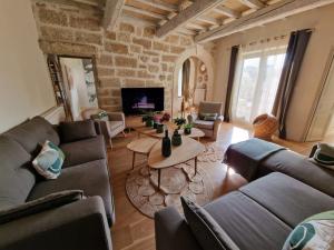 a living room with couches and a table at MAISON BELLEVUE DE SAGRIES in Sagriès