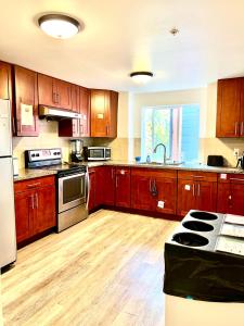 a large kitchen with wooden cabinets and appliances at Studio Apartment with Shared Bathroom 10 minutes walk to University of WA in Seattle