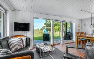 a living room with a couch and a table at Stunning Home In Blvand With 3 Bedrooms, Sauna And Wifi in Blåvand