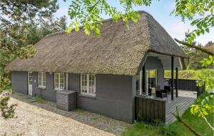 a small gray house with a thatched roof at Stunning Home In Blvand With 3 Bedrooms, Sauna And Wifi in Blåvand