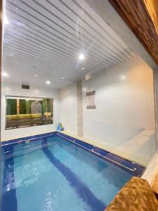 a large swimming pool in a room with a ceiling at شاليهات وفلل ريلاكس بلاس in Sirr Āl Ghalīz̧