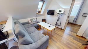 uma sala de estar com um sofá e uma mesa em Apartman Ateliér Vary v nově zrekonstruovaném domě em Karlovy Vary