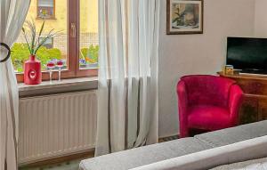 sypialnia z czerwonym krzesłem i oknem w obiekcie 3 Bedroom Stunning Home In Jena w mieście Jena