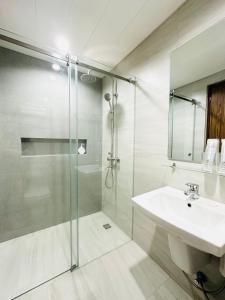 a bathroom with a glass shower and a sink at Furnished Rentals at Mangrove Residences Mactan in Punta Engaño