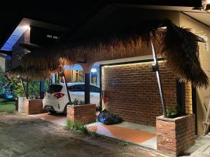 une voiture garée devant un garage la nuit dans l'établissement Grand Lodge Langkawi, à Pantai Cenang