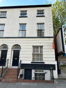 a white building with windows and a staircase at COZY PLACE LIVERPOOL in Liverpool