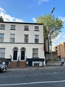 ein weißes Gebäude an der Ecke einer Straße in der Unterkunft COZY PLACE LIVERPOOL in Liverpool