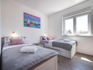 1 dormitorio con 2 camas y 2 ventanas en Apartment Bojana, en Petrčane
