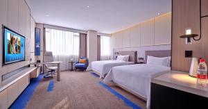 a hotel room with two beds and a television at Hampton by Hilton Shenzhen North Station in Shenzhen