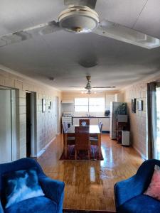 a living room with a table and a kitchen at J & Ella's Holiday House - 2 Bedroom Stays in Cooktown