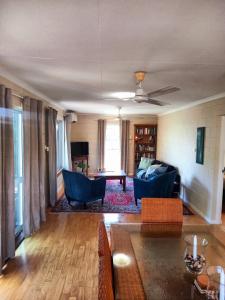 uma sala de estar com um sofá e uma mesa em J & Ella's Holiday House - 2 Bedroom Stays em Cooktown