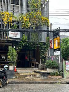 een gebouw met planten aan de zijkant bij Hobnob Hostel in Chiang Mai