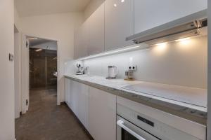a kitchen with white cabinets and a counter top at Luxurious, charming studio perfect for couples in Prague
