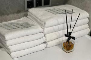 een stapel handdoeken op een tafel met een vaas handdoeken bij Center stay Kaunas - Peledyne - Owl's nest apartments in Kaunas