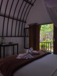 a bed in a room with a window and a bed sidx sidx sidx at Mustika Ocean Lodge in Gili Air