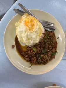 un plato de comida con un huevo encima en Wild Pasir Panjang en Kuah