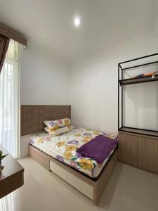 a bedroom with a bed and a large window at Villa Permata Panderman 20 in Batu