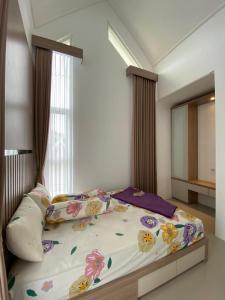 sypialnia z dużym łóżkiem z kwiatami w obiekcie Villa Permata Panderman 20 w mieście Batu