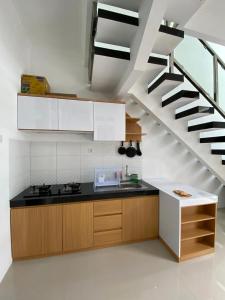 uma cozinha com um lavatório e uma escada em Villa Permata Panderman 20 em Batu