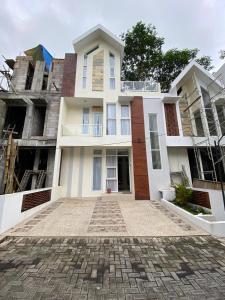 uma grande casa branca com uma calçada de calçada em Villa Permata Panderman 20 em Batu