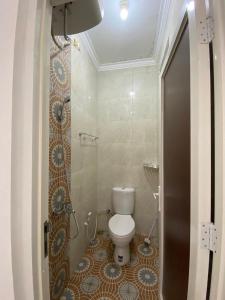 a small bathroom with a toilet and a shower at Villa Permata Panderman 20 in Batu