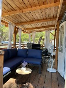 salon z niebieską kanapą na drewnianym tarasie w obiekcie DM mobile home w mieście Jezera