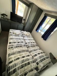 - un lit dans une chambre avec 2 fenêtres dans l'établissement DM mobile home, à Jezera