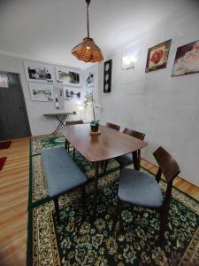 a dining room with a table and chairs on a rug at RAHIM HOMESTAY KUALA KANGSAR in Kuala Kangsar