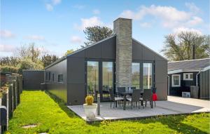 a black house with glass doors and a table and chairs at Awesome Home In Otterup With Wifi in Otterup