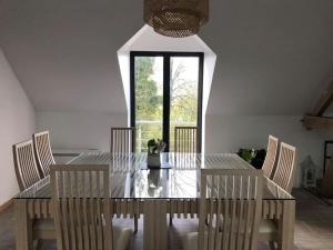 a dining room with a glass table and chairs at Elen's home at the Bucorde in Montville