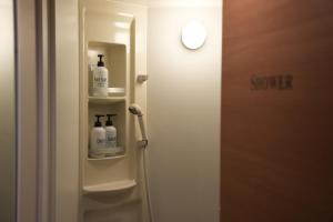 bagno con doccia e 2 bottiglie di sapone di Guest House Tokyo Samurai a Tokyo