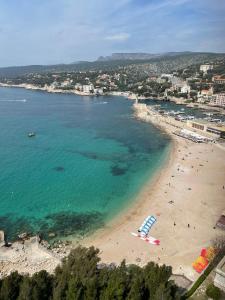 an aerial view of a beach with people in the water at Cassis centre, superbe appartement neuf, 50m port. in Cassis