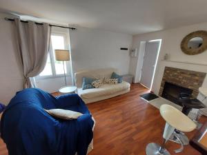 uma sala de estar com um sofá azul e uma lareira em Gîte le Chausey Mont Saint Michel em Pontorson