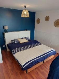 sypialnia z łóżkiem z niebieską ścianą w obiekcie Gîte le Chausey Mont Saint Michel w mieście Pontorson