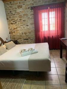 a bedroom with a bed with two towels on it at Habitaciones Rurales La Vertedera I in Villar de Ciervo