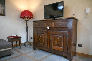 TV en la parte superior de un tocador de madera en una habitación en Povillus - Dimora Medievale, en Quart