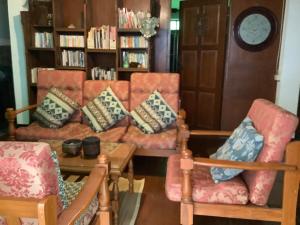 a living room with two chairs and a couch with pillows at Tata GuestHouse in Chiang Mai