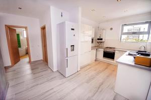 a kitchen with white appliances and a wooden floor at Sara Sea View Apartments - ByChoice in Olimp