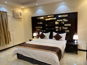 a bedroom with a large bed with a large headboard at ABHASKY in Abha