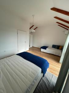 Habitación blanca con cama y sofá en Matisse Residence, en Nerezine