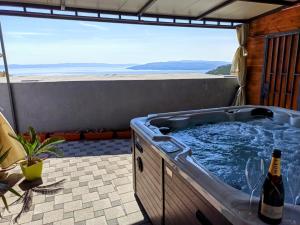 a hot tub on a patio with a bottle of wine at Villa TOP HILL - Private Pool & Jacuzzi in Makarska