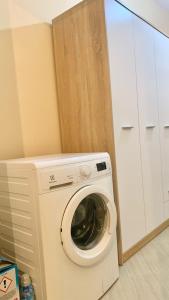 a washer and dryer in a kitchen next to a cabinet at Apartament Real Vlore in Vlorë