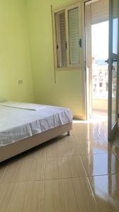 a bedroom with a bed and a sliding glass door at Apartament Real Vlore in Vlorë