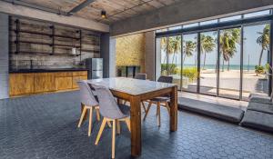 a dining room with a table and chairs and the beach at The Bloc @ Sea in Thap Sakae